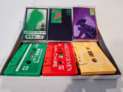 Collection of colorful cassette tapes in a box on a white surface